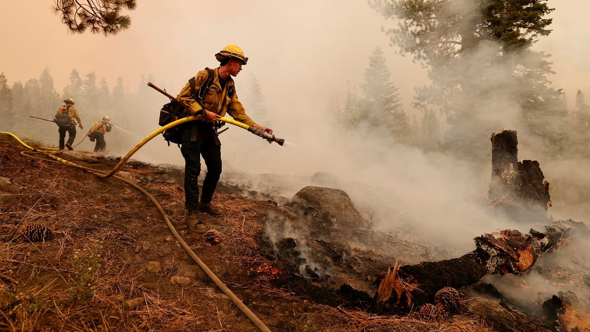 A CalFire hand crew member knocks down a hotspot on the east side of the Caldor Fire near Twin Bridges, California. Credit: Reuters photo