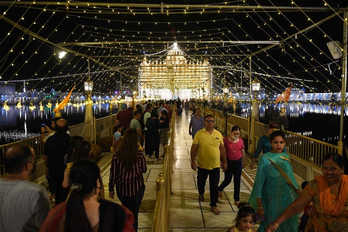 Devotees visit the illuminated Durgiana Temple on the eve of 'Janmashtami' festival marking the birth of Lord Krishna, in Amritsar. Credit: AFP Photo