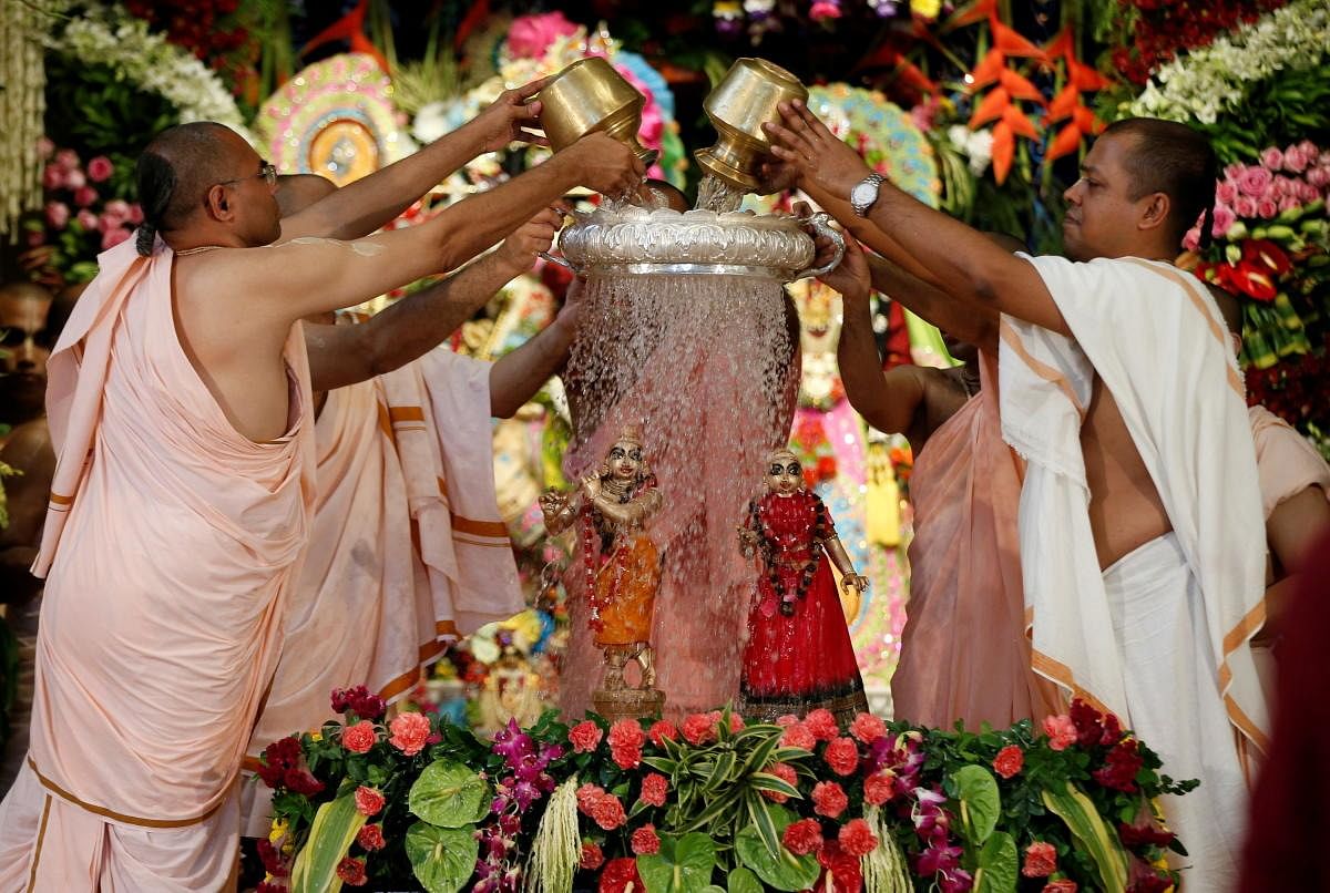Priests pour holy water on the idols of Lord Krishna and goddess Radha during the festival of Janmashtami, marking the birth anniversary of Lord Krishna, at a temple in Ahmedabad. Credit: Reuters Photo