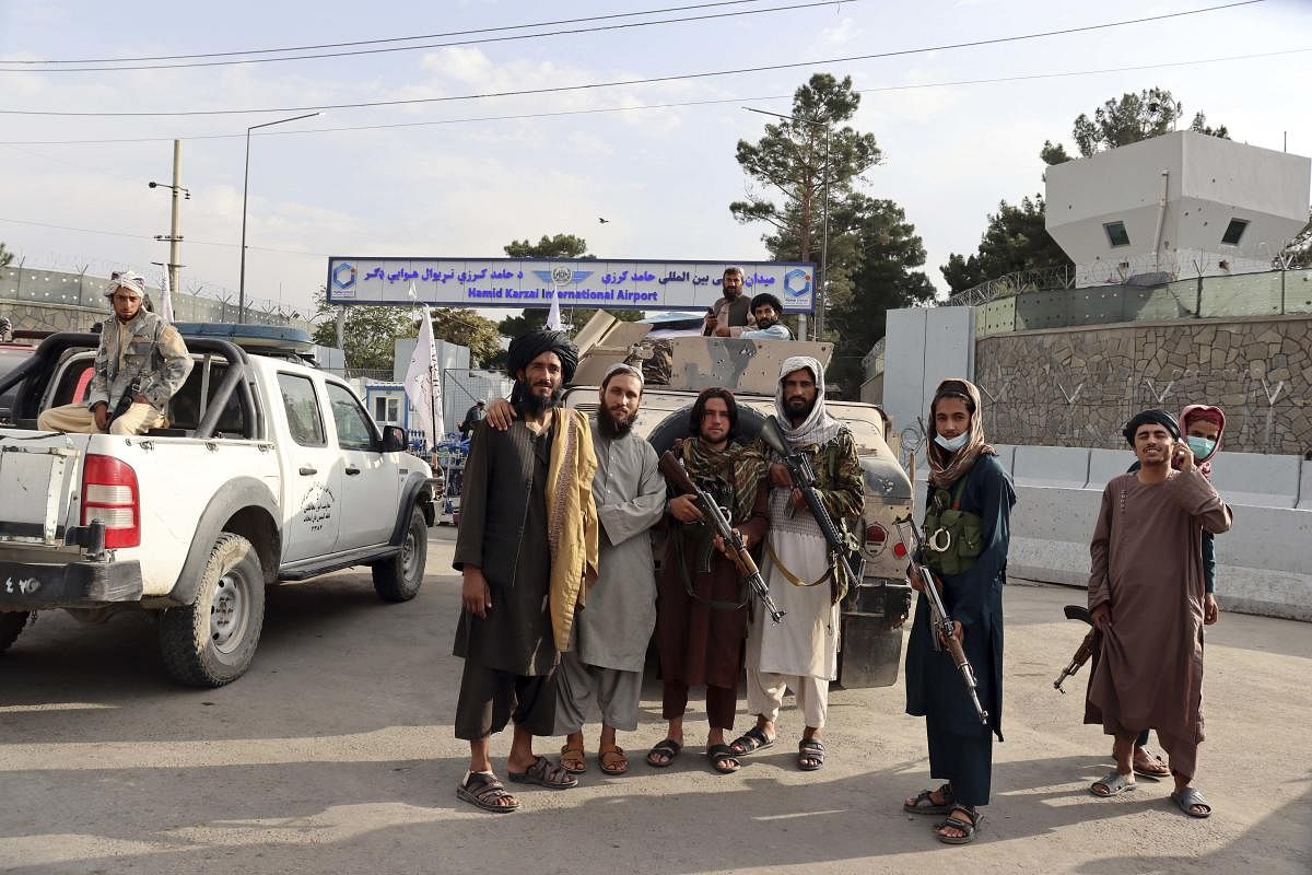 Taliban fighters stand guard in front of the Hamid Karzai International Airport after the US withdrawal in Kabul, Afghanistan, Tuesday, Aug. 31, 2021.  Credit: PTI Photo