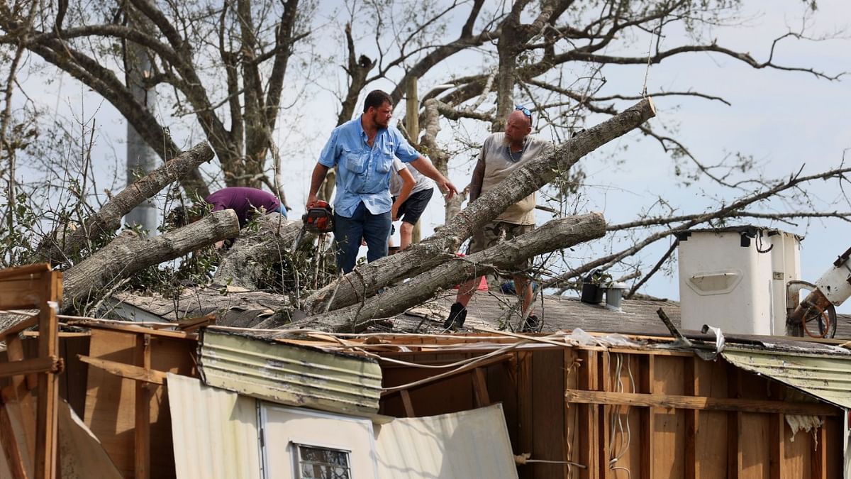 Workers remove a tree from the roof of a mobile home after it fell on the home during Hurricane Ida in Houma, Louisiana. Ida made landfall August 29, as a category 4 storm southwest of New Orleans. Credit: Scott Olson/Getty Images/AFP Photo