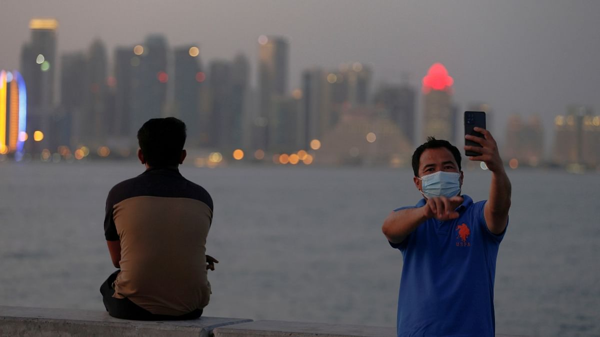 A man takes a selfie with his smartphone at sunset during a corniche walk in Doha. Credit: Reuters Photo