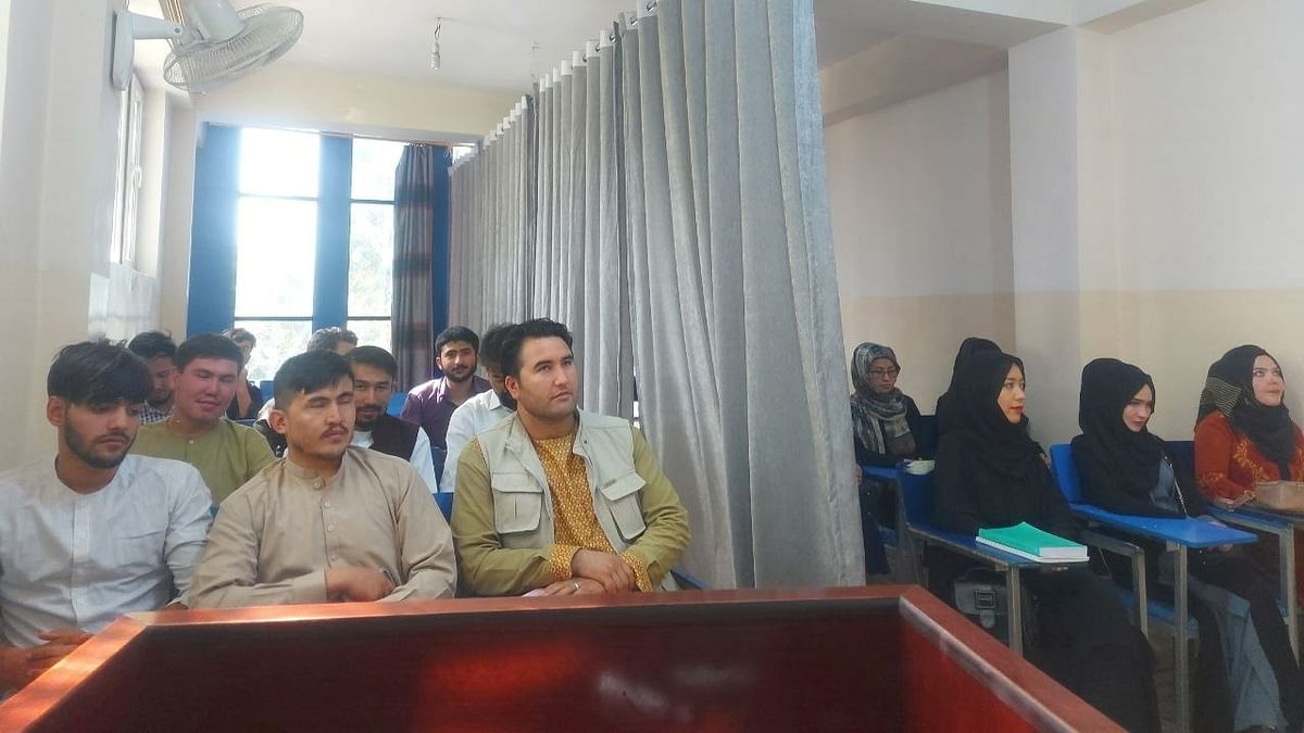 Photographs shared by Avicenna University in Kabul, and widely circulated on social media, show a grey curtain running down the centre of the classroom, with female students wearing long robes and head coverings but their faces visible. Credit: Reuters Photo