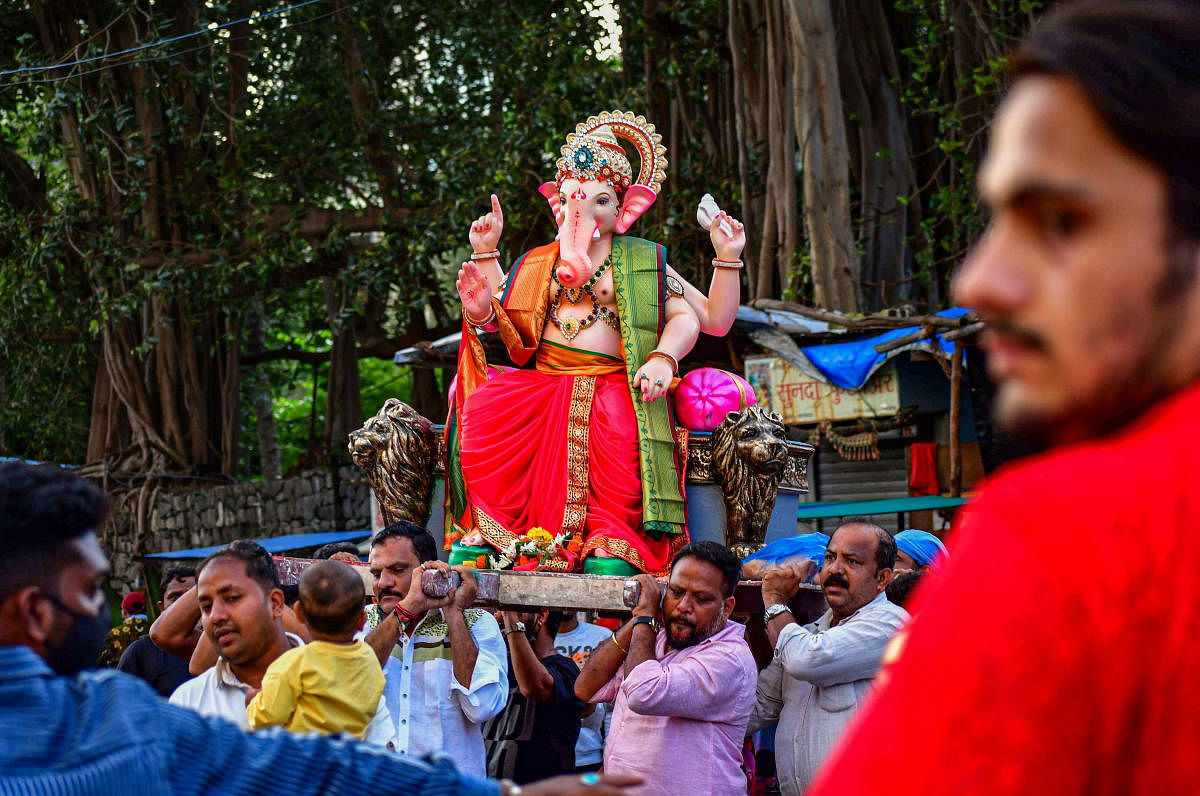Devotees carry an idol of Lord Ganesha ahead of the Ganesh Chaturthi fetival at Lalbaug in Mumbai, Maharashtra. Credit: PTI Photo