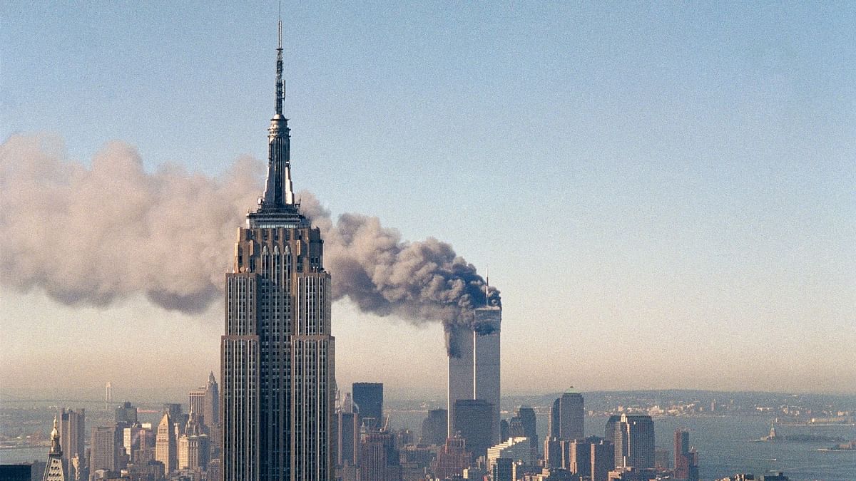 The twin towers of the World Trade Center burn behind the Empire State Building on September 11, 2001. Credit: AP/File Photo