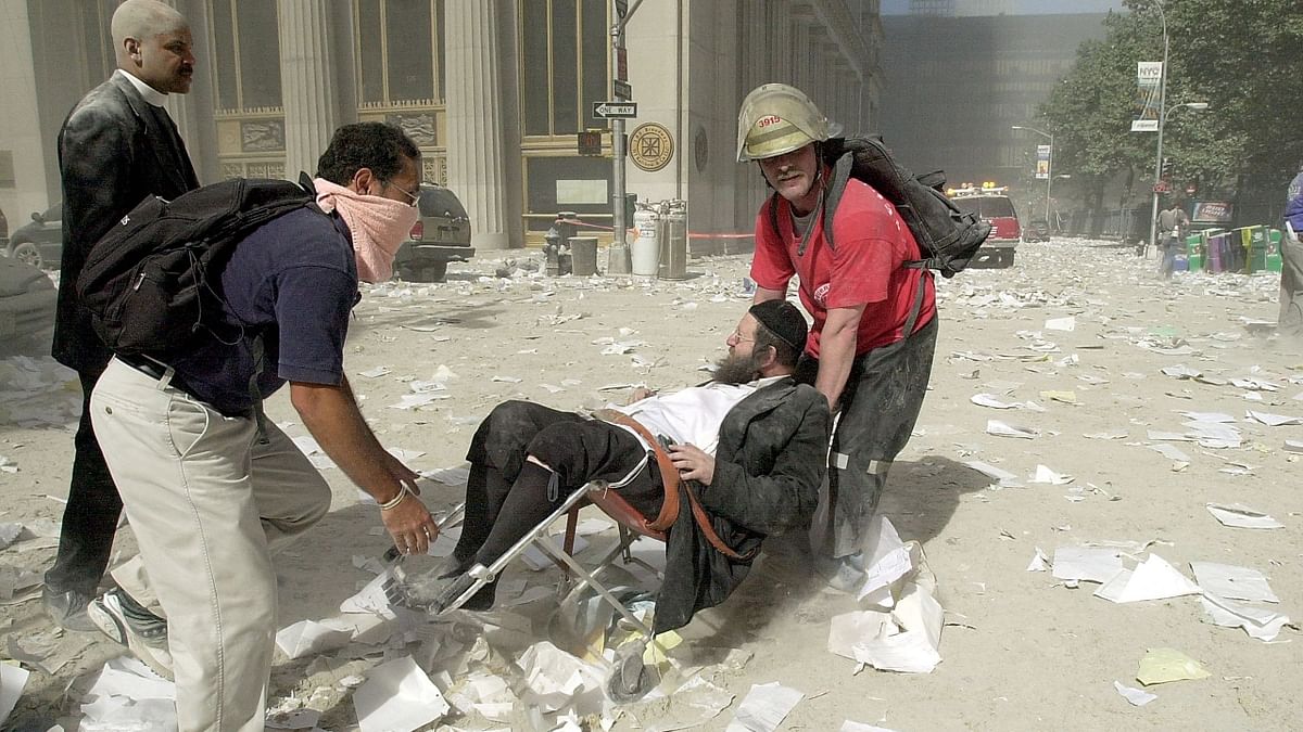 Rescue workers evacuate a man through rubble and debris after the collapse of one of the World Trade Center Towers in New York. Credit: AFP/File Photo