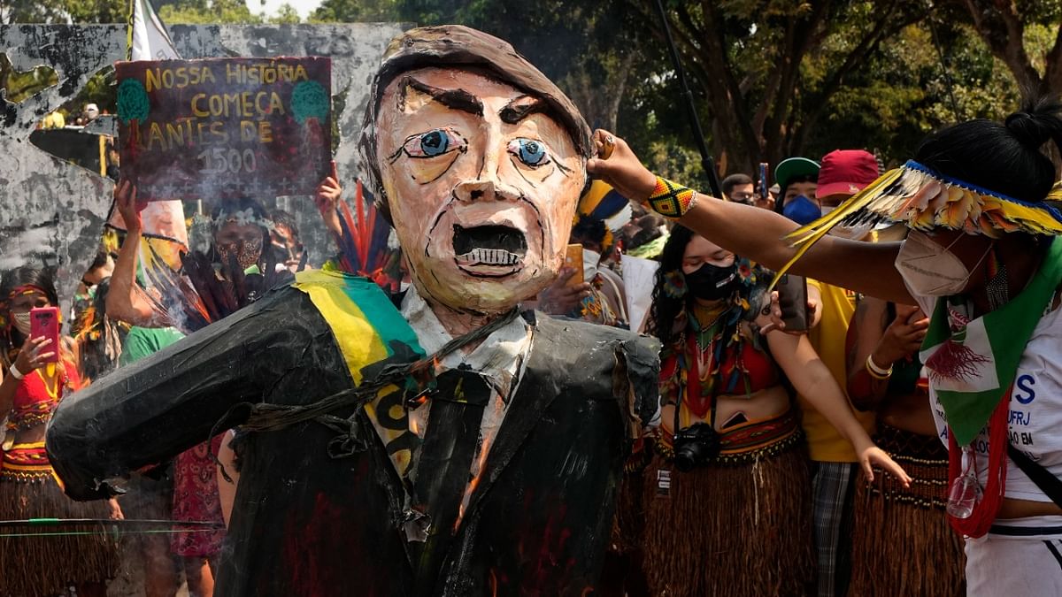 Indigenous women burn an effigy of Brazilian President Jair Bolsonaro during a march to protest Bolsonaro's policies and in favour of women's rights and the demarcation of Indigenous lands in Brasilia. Credit: AP/PTI Photo