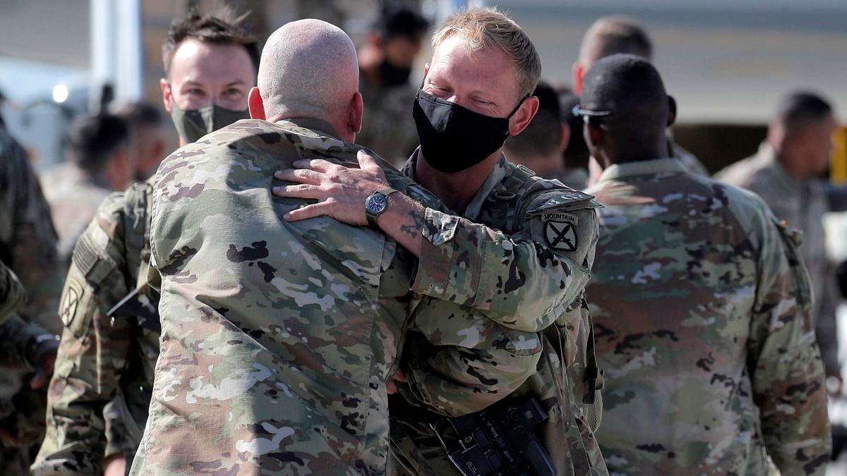 Soldiers exchange warm hugs on their return from Afghanistan. Credit: Reuters Photo