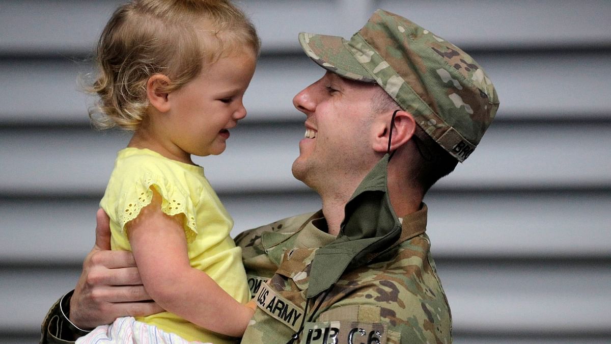 Captain Swasey Brown, a soldier with the 4th Battalion, 31st Infantry Regiment, 2nd Brigade Combat Team of the 10th Mountain Division, holds his daughter after returning to US from deployment in Afghanistan. Credit: Reuters Photo