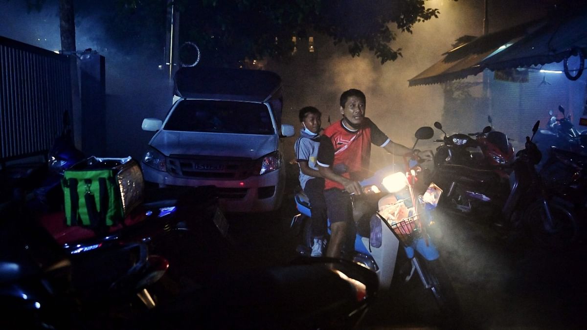 Residents retreat from tear gas as anti-government protesters clash with police at a demonstration in Bangkok. Credit: AFP Photo