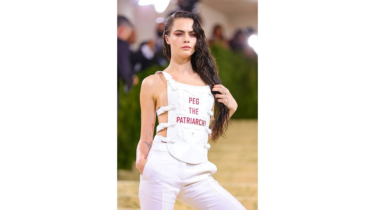 Actress and singer Cara Delevingne wore a white tank top with matching pants. The T-shirt read,