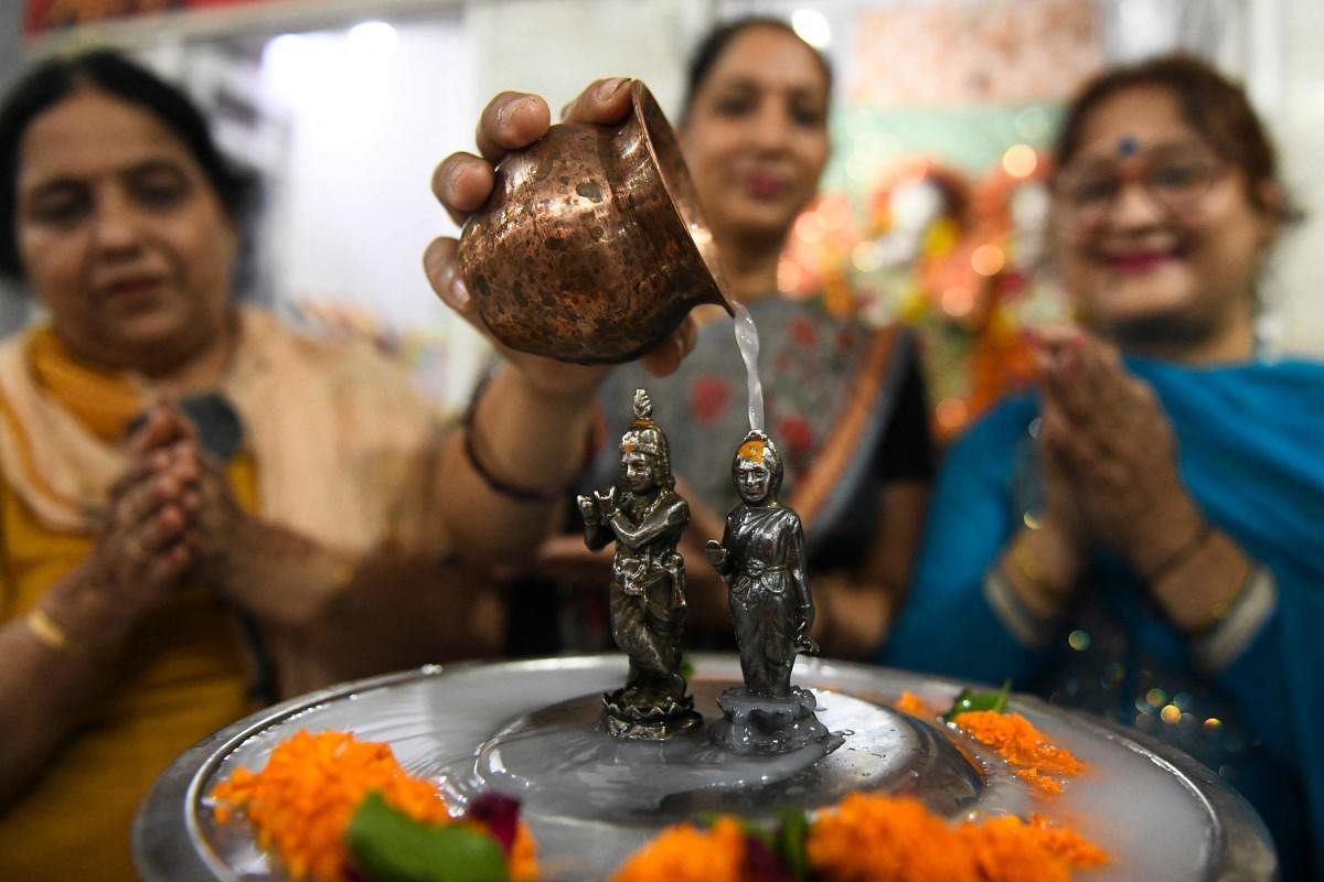 Hindu devotees pour milk over the idols of Goddess Radha and Lord Krishna on the occasion od Radha Ashtami at a temple in Amritsar. Credit: AFP Photo