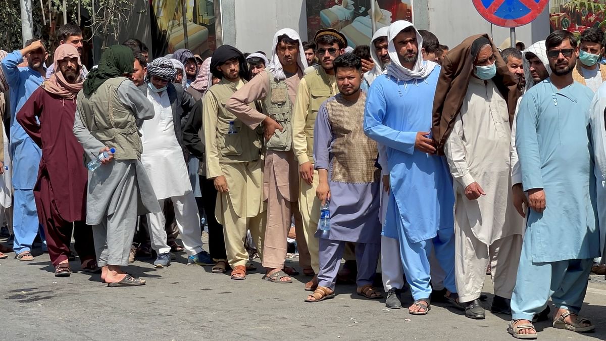 Afghans line up outside a bank to take out their money after Taliban takeover in Kabul, Afghanistan. Many businesses and banks remain shut and prices for staples are rapidly climbing ever since the Taliban takeover. Credit: Reuters Photo