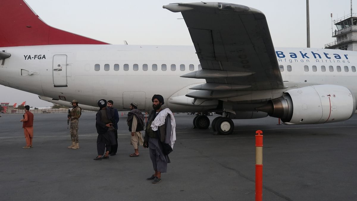 Members of the Taliban oversee the movement on the runway of the international airport in Kabul, Afghanistan. Scenes of chaos at Kabul airport made global headlines last month. Several people died as Taliban members open fire and due to stampede. Credit: Reuters Photo