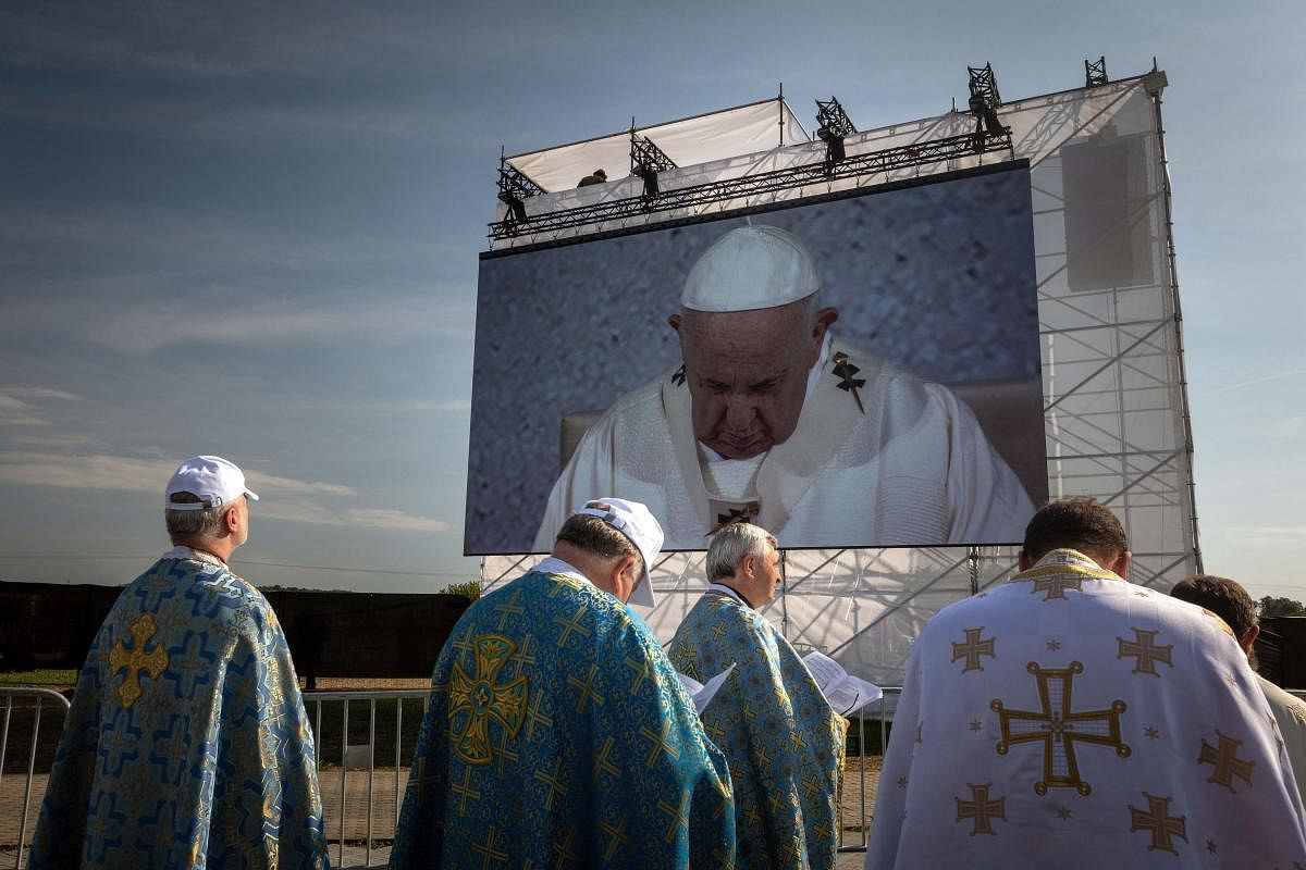 Clergymen stand in front of a canvas displaying Pope Francis as he celebrates an open air Holy Mass at The National Shrine in Sastin-Straze, some 70 km north of the Slovakian capital Bratislava. Credit: AFP Photo