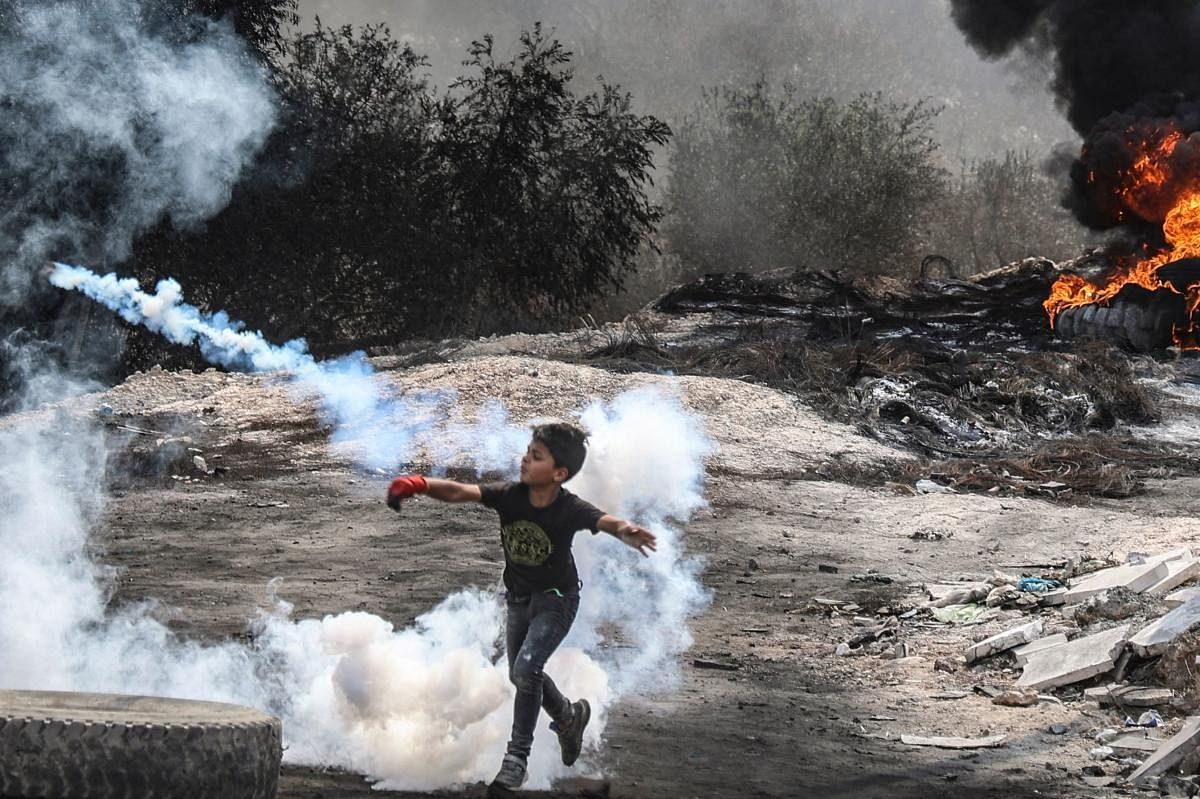A young Palestinian boy joins fellow protesters in confrontations with Israeli security forces, following a demonstration against settlements in the West Bank village of Beita. Credit: AFP Photo