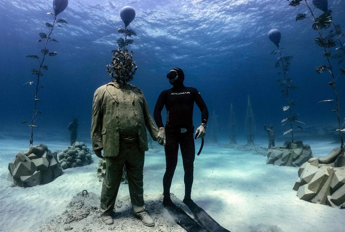 Cypriot freediver Angels Savvas poses with a sculpture in the MUSAM underwater sculpture park, billed as the world’s first underwater forest, consisting of a collection of 130 submarine figurative sculptures dispersed amongst a series of sculpted organic trees and subterranean plants, in the Ayia Napa resort town on the southeastern coast of Cyprus. Credit: AFP Photo