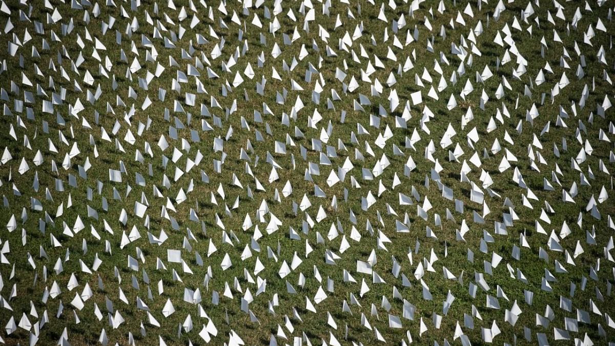 In this elevated view, flags fly at the 'In America: Remember' public art installation near the Washington Monument on September 19, 2021 in Washington, DC. The installation commemorates all the Americans who have died due to Covid-19. Credit: AFP Photo