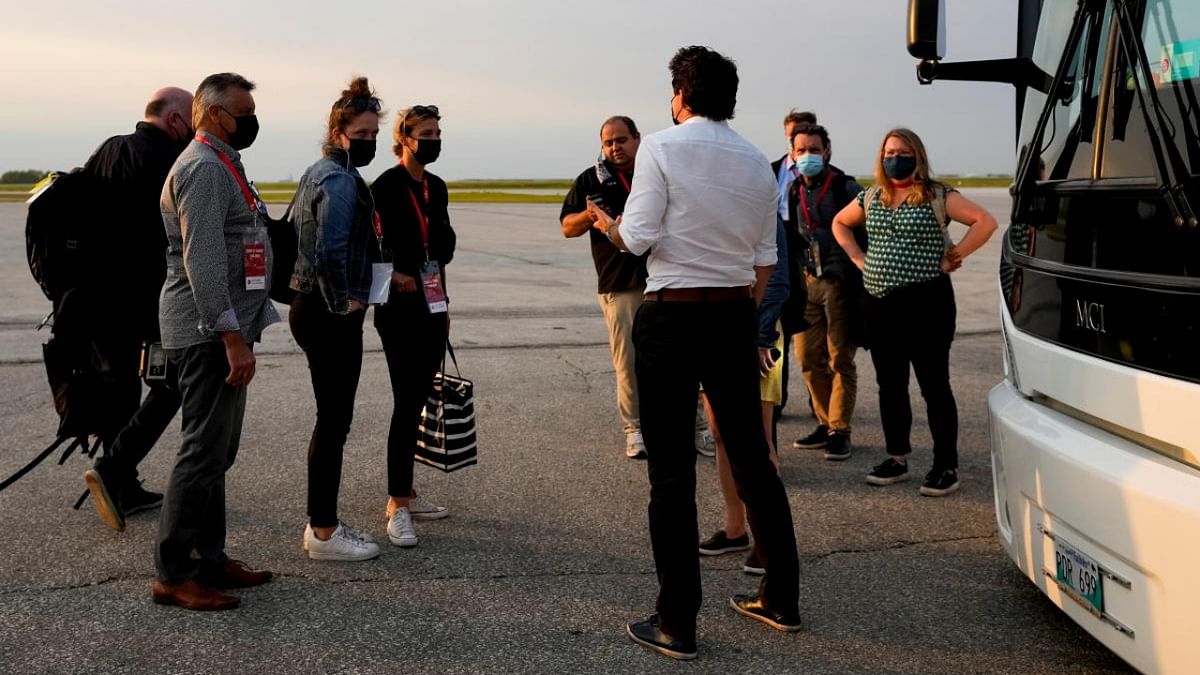 Canada's Liberal Prime Minister Justin Trudeau speaks with journalists and his staff after getting off his plane on the last campaign day before the election, in Winnipeg, Manitoba. Credit: Reuters photo