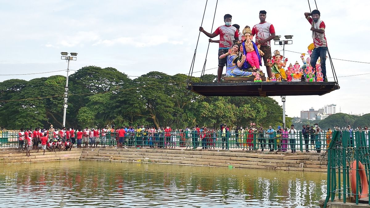 Volunteers carry idols of Lord Ganesh in a crane for their immersion in a makeshift pond at Ulsoor lake following Ganesh Chaturthi festival, in Bengaluru. Credit: PTI Photo