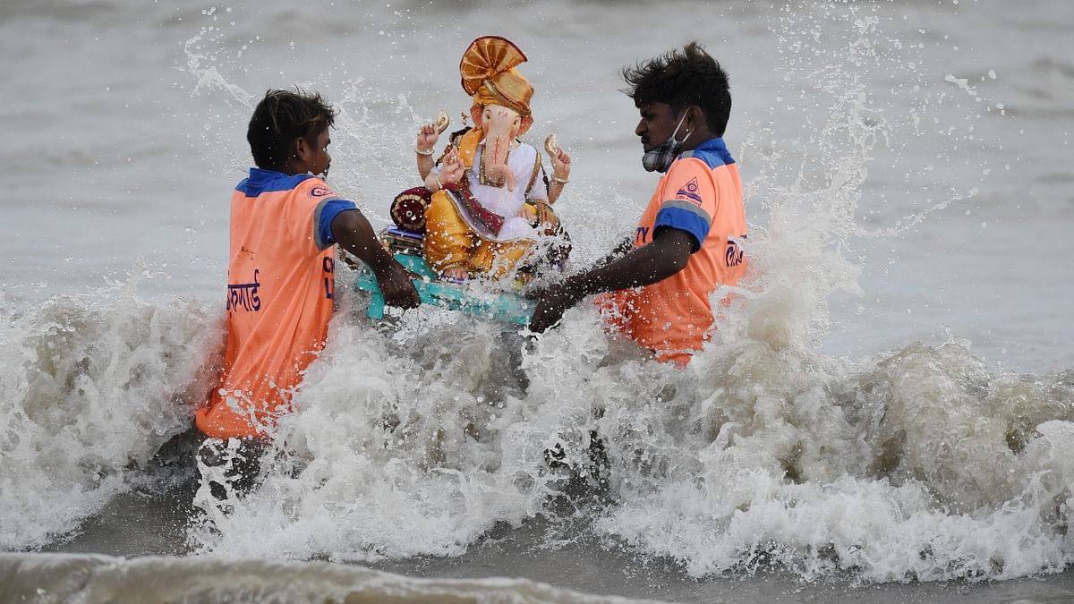 Volunteers immerse an idol of god Ganesha in the Arabian Sea during the Ganesh Chaturthi festival, at Girgaon Chowpatty in Mumbai. Credit: PTI Photo