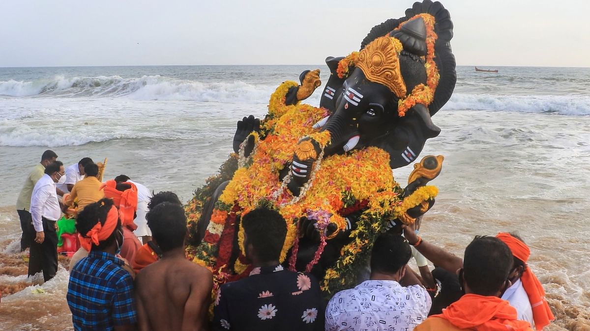 Devotees immerse an idol of Lord Ganesh at Shanghumugham beach during the Ganesh Chaturthi celebration, in Thiruvananthapuram. Credit: PTI Photo