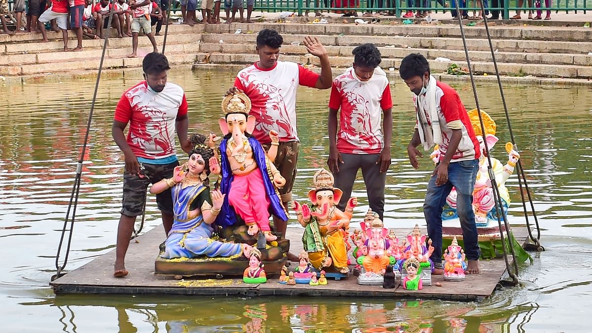 Volunteers carry idols of Lord Ganesh in a crane for their immersion at Ulsoor lake in Bengaluru. Credit: PTI Photo