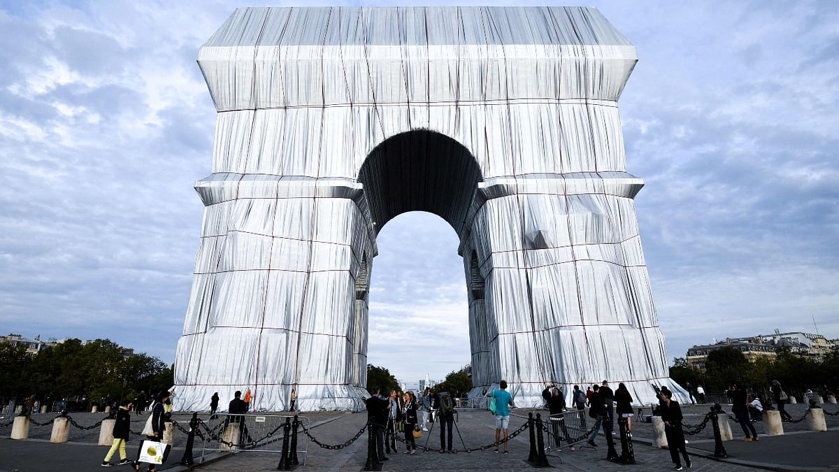 Crowds of Parisians and tourists strolled along the Champs-Elysees avenue along the most famous thoroughfare in Paris to view the Arc de Triomphe in its temporary guise as an art installation. The monument has been covered in silvery wrapping, as conceived by the late artist Christo. Credit: AFP Photo