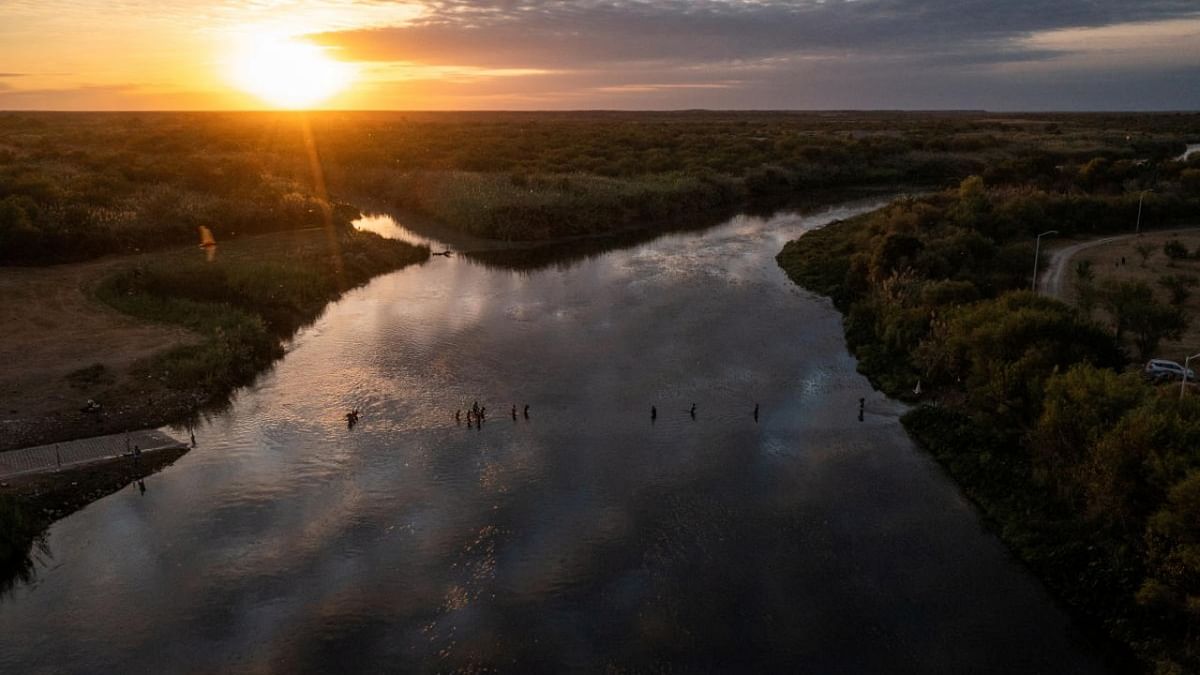 Migrants seeking refuge in United States cross the Rio Grande river back across the border into Ciudad Acuna, Mexico from their camp in Del Rio, Texas. Credit: Reuters photo