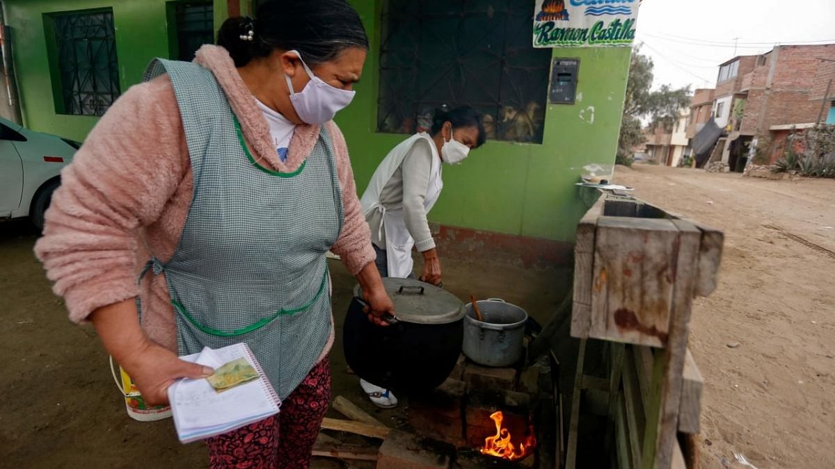 Volunteers cook at a soup kitchen in Trujillo, La Libertad, Peru, on September 22, 2021. - Peruvian women around the country are organizing soup kitchens, which through donations, feed hundreds of low-income families amid the economic crisis triggered by the Covid-19 pandemic. Credit: AFP Photo