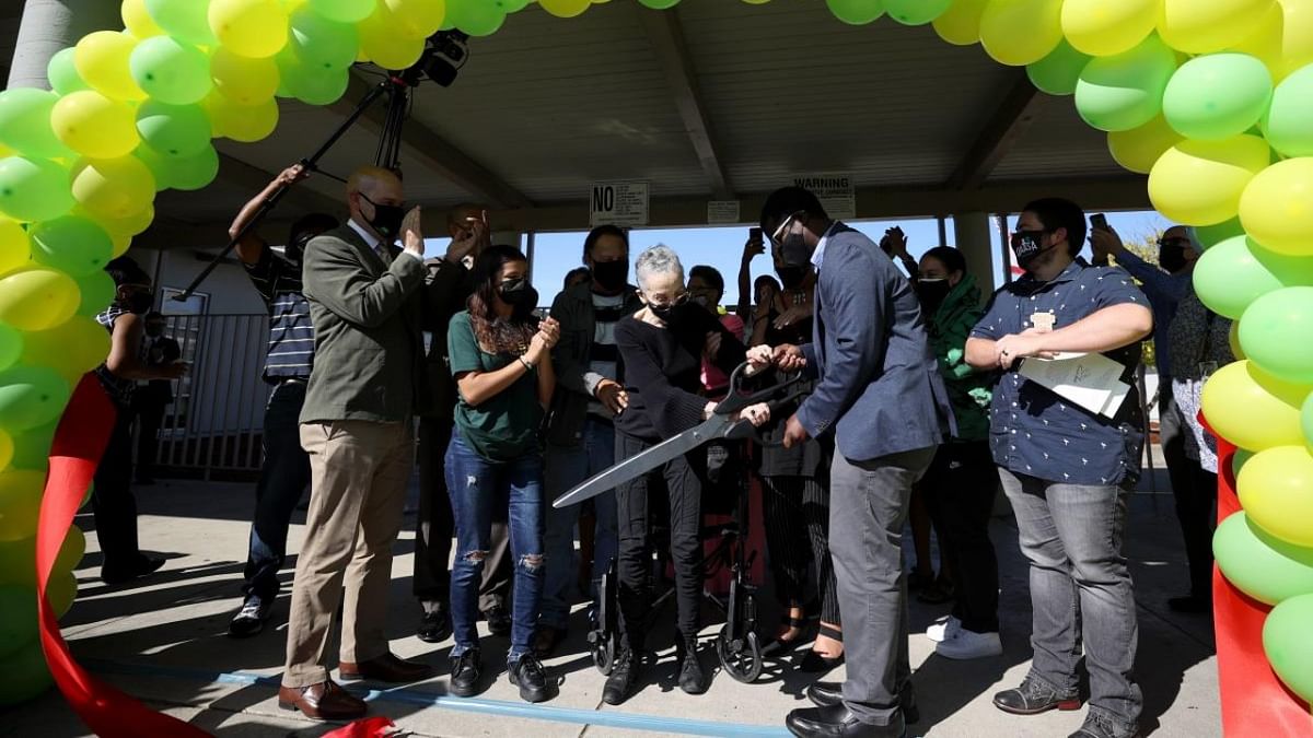 Betty Reid Soskin, (C) the oldest full-time National Park Service ranger in the United States, uses large scissors to cut a ribbon during a renaming ceremony for the newly named Betty Reid Soskin Middle School on September 22, 2021 in El Sobrante, California. Credit: AFP Photo