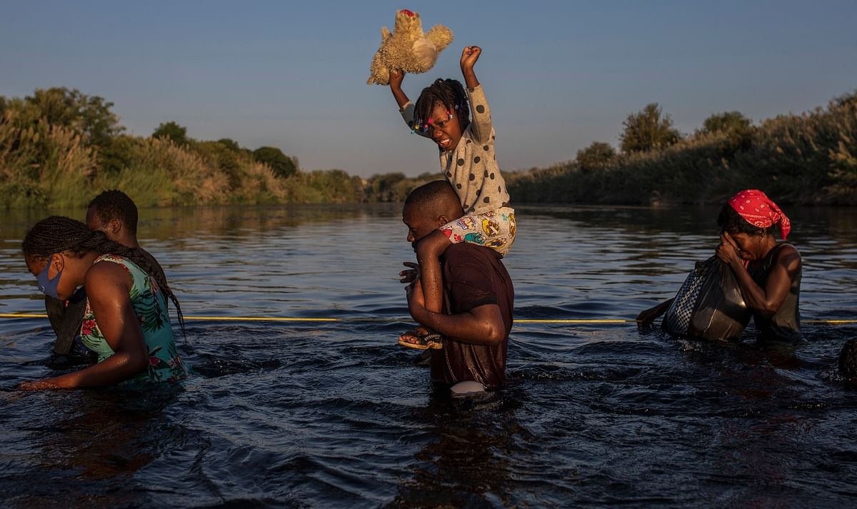 Haitians carried their children, belongings on their heads as they crossed the river. Credit: AFP Photo