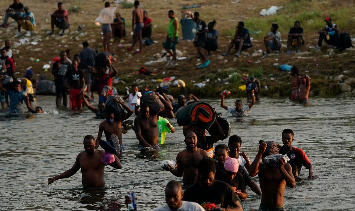 In recent days, thousands of Haitians crossed the Rio Grande into the US. Some then waded back through the river to buy supplies in Mexico before returning to the Texas encampment. Credit: AFP Photo