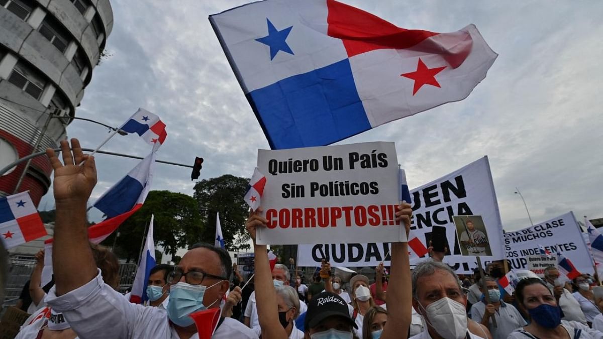 Demonstrators sing the national anthem with a sign reading “I want a country without corrupt politicians” during a protest outside the National Asembly, in Panama City, on September 23, 2021. Credit: AFP Photo