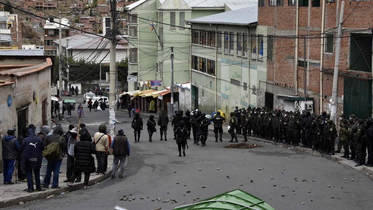 Riot police stand guard outside the headquarters of the Coca Leaf Producers Department Association (ADEPCOCA) to prevent a group of coca leaf producers take over them, in La Paz. Credit: AFP Photo