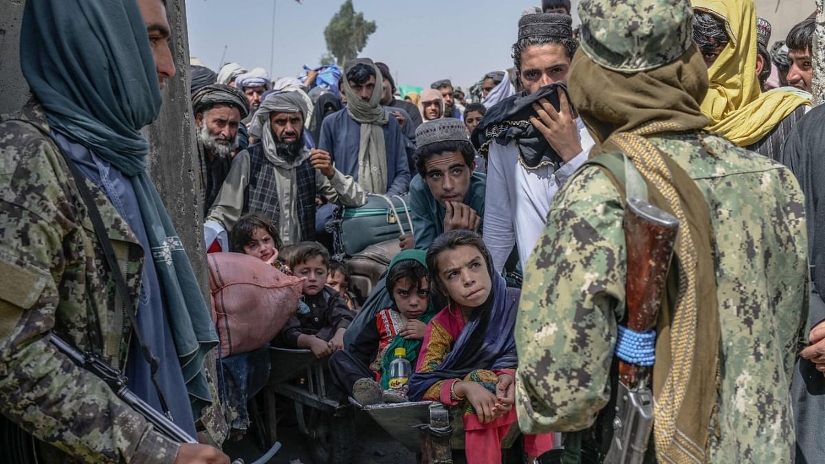 People stand as Taliban members stopped them while rushing to pass to Pakistan from the Afghanistan border in Spin Boldak. Credit: AFP Photo