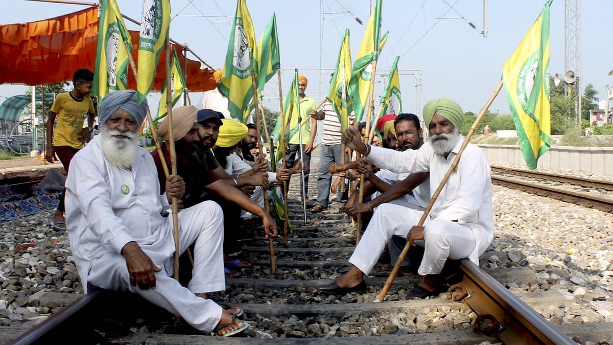 Members of Bhartya Kisan Union Ugrahan block railway tracks during farmers' Bharat Bandh, at Dhablaan village near Patiala. Credit: PTI Photo