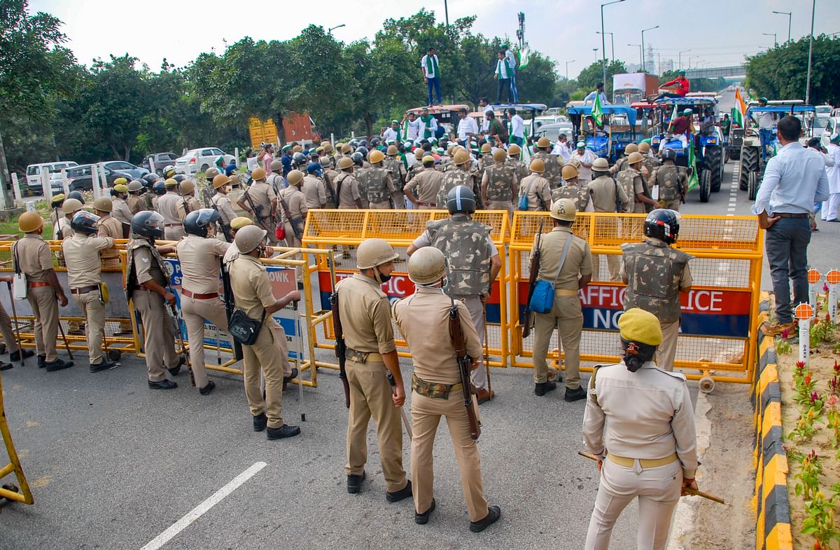 Police personnel put barricades to stop Bharatiya Kisan Union members during farmers' Bharat Bandh against the central government's three farm laws, in Noida. Credit: PTI Photo