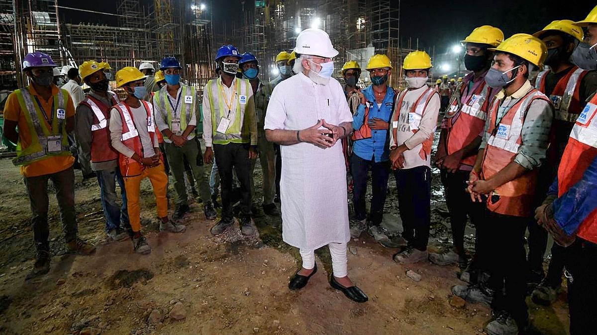 In this photo, PM Modi is seen interacting with the site workers during his visit to the new Parliament building in New Delhi on September 26, 2021. Credit: PTI Photo