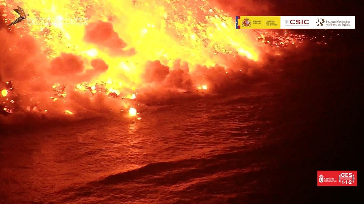 A bright red river of lava from the volcano on Spain's La Palma Island tumbled over a cliff and into the Atlantic Ocean, setting off huge plumes of steam and possibly toxic gases that required local residents outside the evacuation zone to remain indoors. Credit: Reuters Photo