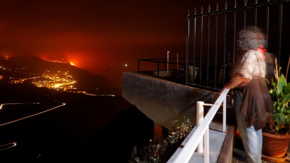 A woman watches from Tijarafe as lava flows into the sea following the eruption of a volcano on the Canary Island of La Palma, Spain. Credit: Reuters Photo