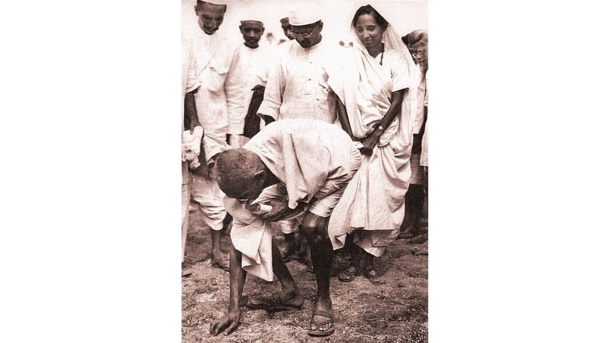 Gandhiji ceremoniously breaking the salt law by picking up a lump of natural salt at Dandi on April 6, 1930. Credit: www.gandhi.gov.in