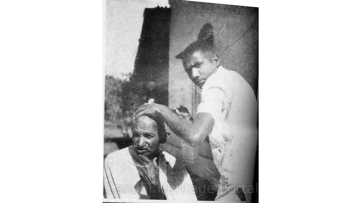 Getting a haircut from Abbasbhai Khushalbhai Varteji. Credit: www.gandhi.gov.in