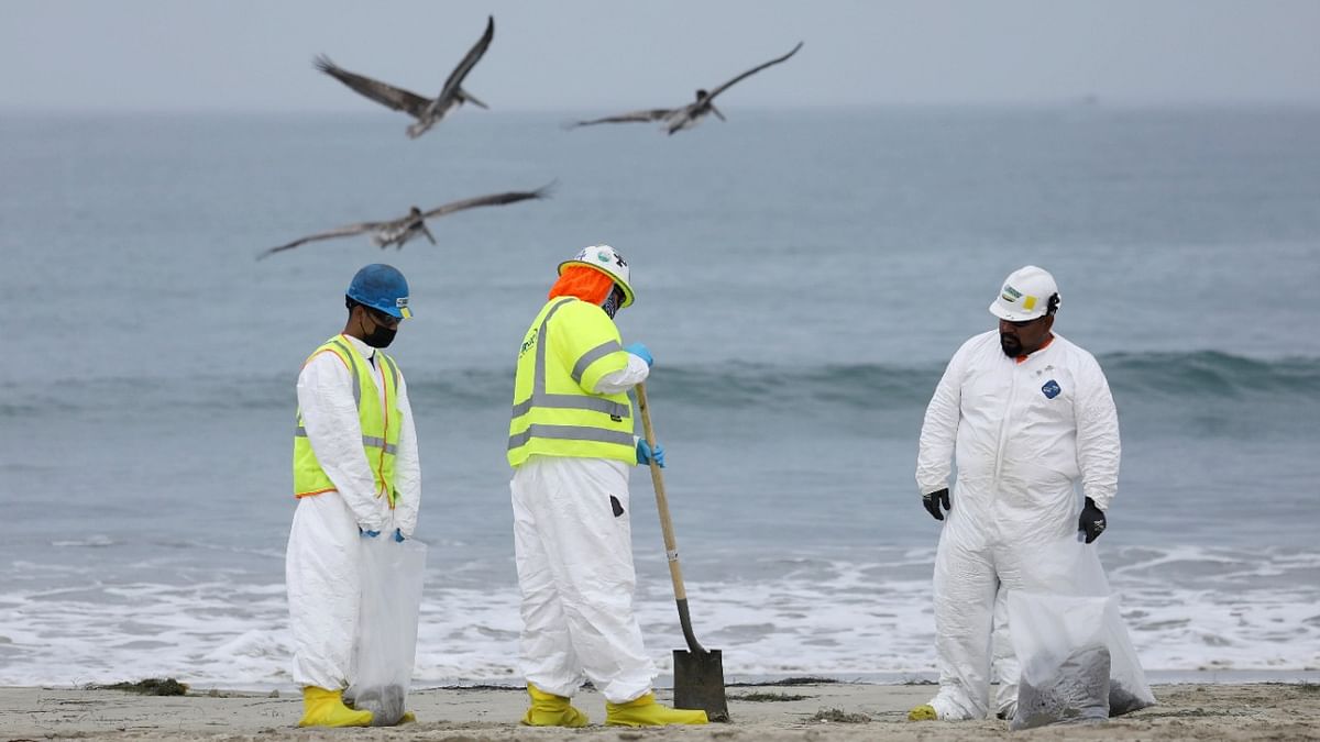 Workers rake up crude oil, after more than 3,000 barrels (126,000 gallons) of crude oil leaked from a ruptured pipeline into the Pacific Ocean in Newport Beach, California. Credit: Reuters Photo
