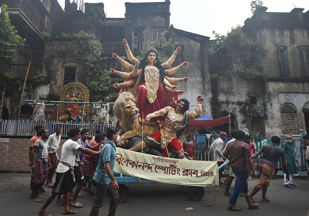 Devotees carry a Durga idol for worship to a pandal. Credit: PTI Photo