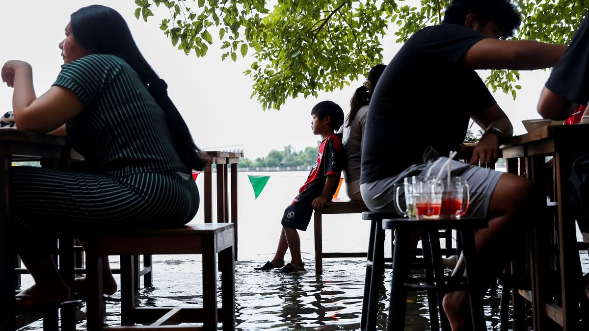 Instead of closing for the floods, Titiporn's eatery is making waves in Thailand, staying open for customers who are revelling in shin-deep dining, and the thrill of avoiding the rush of water set off as boats go by. Credit: Reuters Photo