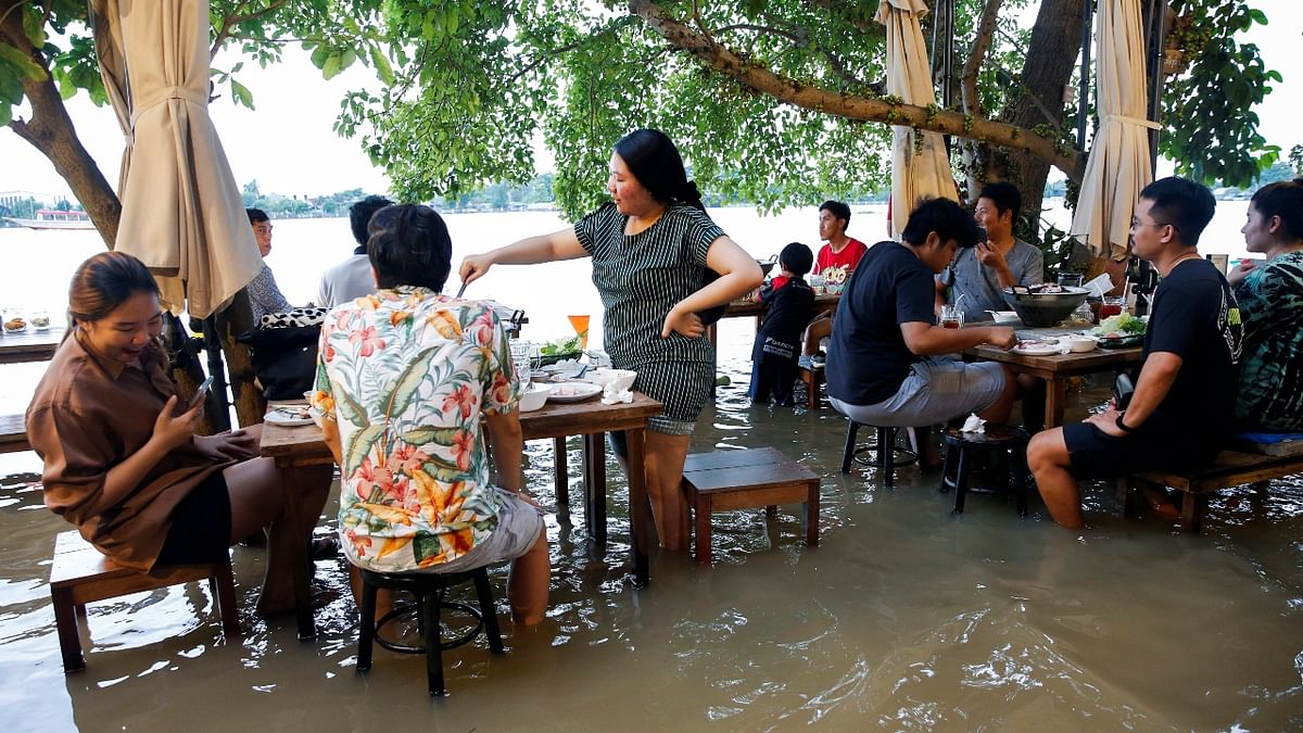 A flood-hit riverside restaurant in Thailand has become an unlikely dining hotspot after fun-loving foodies began flocking to its waterlogged deck to eat amid the lapping tide. Credit: Reuters Photo