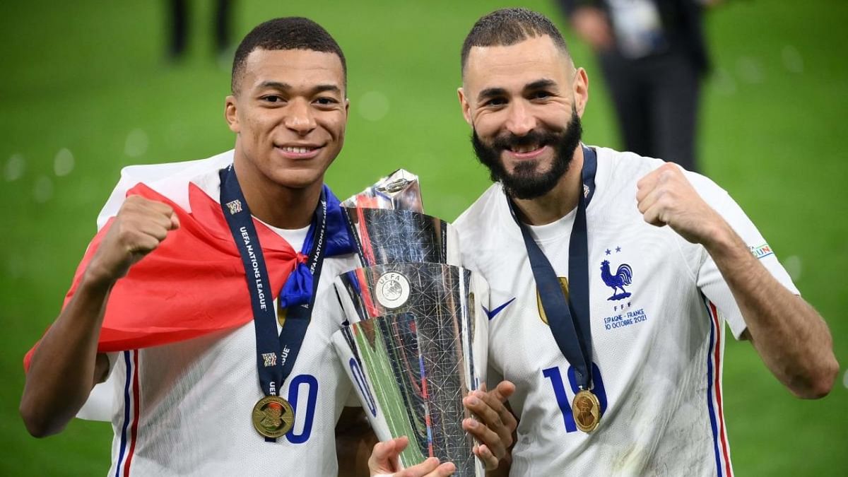 France's forward Kylian Mbappe (L) and France's forward Karim Benzema (R) celebrate with the trophy at the end of the Nations League final football match between Spain and France at San Siro stadium in Milan. Credit: AFP Photo