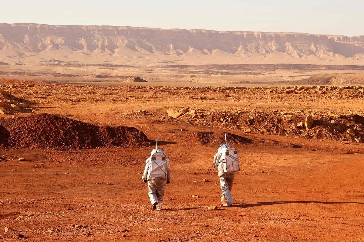 A couple of astronauts from a team from Europe and Israel walk in spacesuits during a training mission for planet Mars at a site that simulates an off-site station at the Ramon Crater in Mitzpe Ramon in Israel's southern Negev desert. Credit: AFP Photo