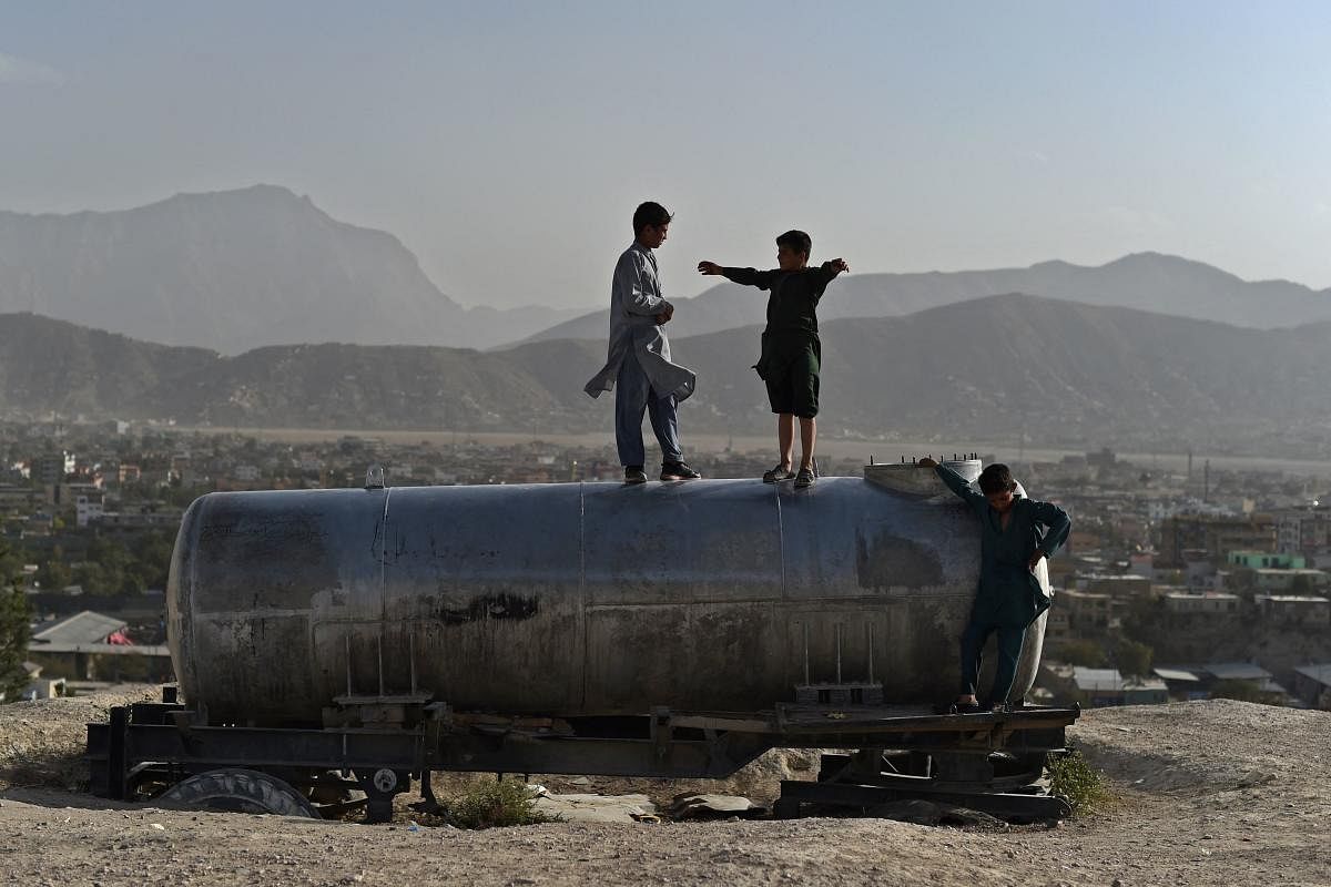 Afghan boys play on a water tanker at Nadir Khan hilltop overlooking Kabul. Credit: AFP Photo